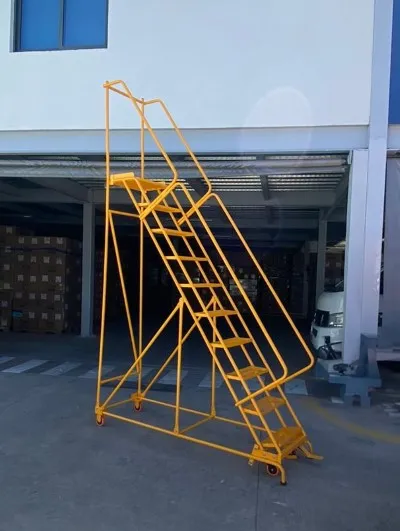 Un tipo de escaleras industriales de gran altura que tiene barandales y está colocada en un entorno exterior de almacenes.